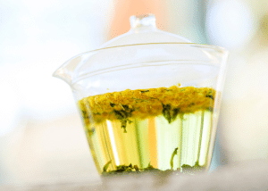 un pot en verre avec du mimosa qui infuse dans l'eau